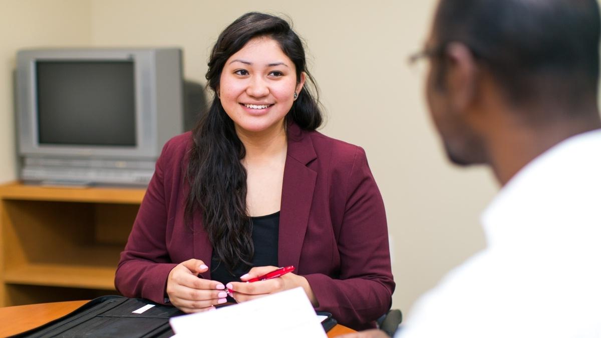 a woman participates in a mock interview in the career services office